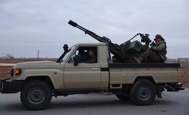 Syrian government soldiers drive a vehicle with heavy machine gun mounted on top on a road leading to the town of Deir Hafer, Syria, Saturday, Jan. 17, 2026. (AP Photo/Ghaith Alsayed)