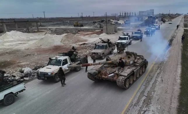 A convoy of Syrian government forces drives on a road leading to the town of Deir Hafer, Syria, Saturday, Jan. 17, 2026. (AP Photo/Ghaith Alsayed)