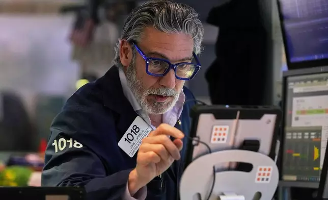 Trader John Romolo works on the floor of the New York Stock Exchange, Monday, Jan. 12, 2026. (AP Photo/Richard Drew)