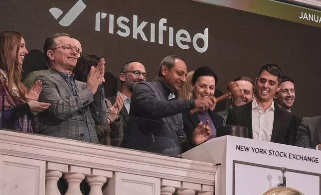 Ravi Kumaraswami, center, Riskified President of Worldwide Field Operations., gavels trading closed at the New York Stock Exchange, Monday, Jan. 12, 2026. (AP Photo/Richard Drew)