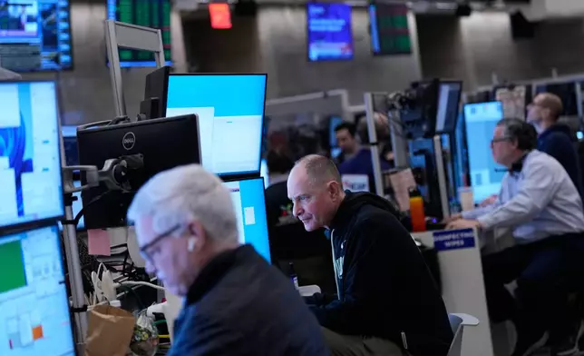 Traders work on the floor at the New York Stock Exchange in New York, Friday, Jan. 9, 2026. (AP Photo/Seth Wenig)