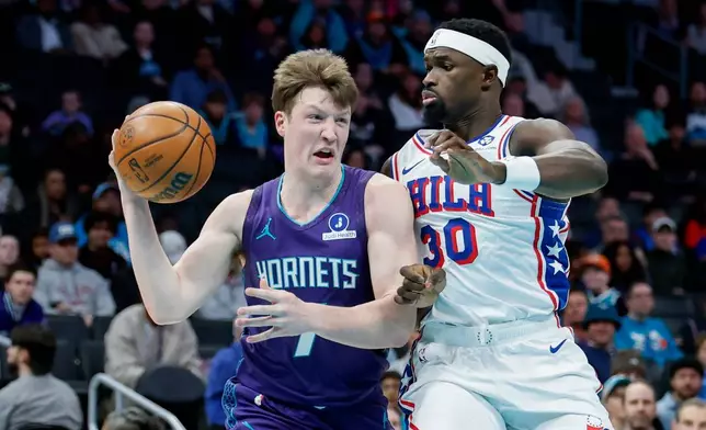 Charlotte Hornets guard Kon Knueppel, left, passes against Philadelphia 76ers center Adem Bona (30) during the first half of an NBA basketball game in Charlotte, N.C., Monday, Jan. 26, 2026. (AP Photo/Nell Redmond)