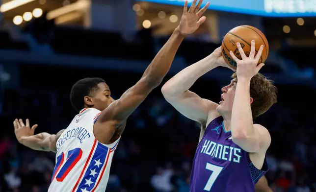 Charlotte Hornets guard Kon Knueppel (7) looks to shoot over Philadelphia 76ers guard V.J. Edgecombe during the first half of an NBA basketball game in Charlotte, N.C., Monday, Jan. 26, 2026. (AP Photo/Nell Redmond)
