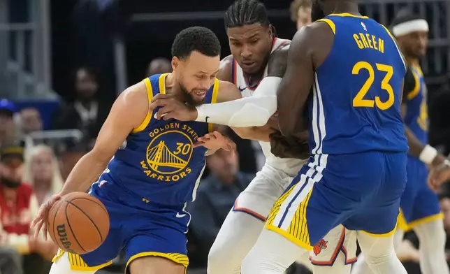 Golden State Warriors guard Stephen Curry (30) dribbles the ball as forward Draymond Green (23) screens New York Knicks guard Miles McBride, middle, during the first half of an NBA basketball game in San Francisco, Thursday, Jan. 15, 2026. (AP Photo/Jeff Chiu)