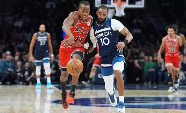 Chicago Bulls guard Ayo Dosunmu (11) and Minnesota Timberwolves guard Mike Conley (10) try to gain possession of the ball during the first half of an NBA basketball game, Thursday, Jan. 22, 2026, in Minneapolis. (AP Photo/Abbie Parr)