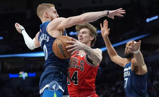Chicago Bulls forward Matas Buzelis (14) looks to pass the ball against Minnesota Timberwolves guard Donte DiVincenzo (0) and center Rudy Gobert (27) during the first half of an NBA basketball game, Thursday, Jan. 22, 2026, in Minneapolis. (AP Photo/Abbie Parr)