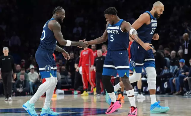 Minnesota Timberwolves forward Julius Randle, left, celebrates with guard Anthony Edwards (5) after making a 3-point basket during the first half of an NBA basketball game against the Chicago Bulls, Thursday, Jan. 22, 2026, in Minneapolis. (AP Photo/Abbie Parr)