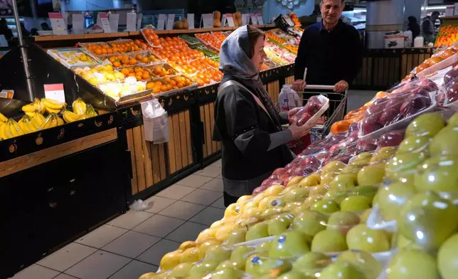 People shop fruits at a store in Tehran, Iran, Friday, Jan. 16, 2026. (AP Photo/Vahid Salemi)