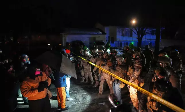 Law enforcement officers at the scene of a reported shooting Wednesday, Jan. 14, 2026, in Minneapolis. (AP Photo/Adam Gray)