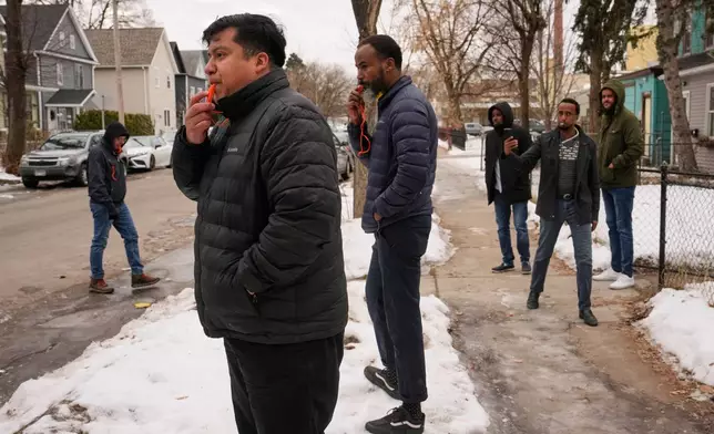 Minneapolis City Council Member Jason Chavez, second from left, blows a whistle with other activists to warn people of federal immigration officers Thursday, Jan. 15, 2026, in Minneapolis. (AP Photo/John Locher)