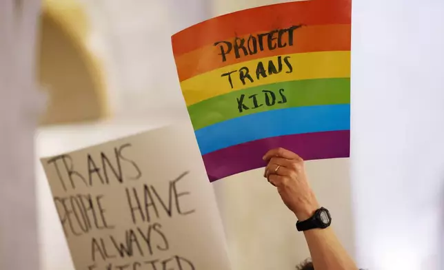 FILE - Protestors hold signs during a rally at the state capitol in Charleston, W.Va., on March 9, 2023. (AP Photo/Chris Jackson, file)