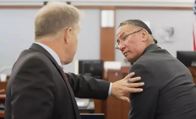 Nathan Chasing Horse, right, talks to his attorney Craig Mueller during his trial on charges of sexually abusing Indigenous women and girls Tuesday, Jan. 13, 2026, in Las Vegas. (AP Photo/Ty ONeil)