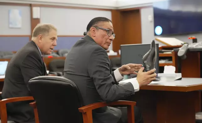 Nathan Chasing Horse, right, sitting next to attorney Craig Mueller, holds a shoe as he appears for his trial on charges of sexually abusing Indigenous women and girls Tuesday, Jan. 13, 2026, in Las Vegas. (AP Photo/Ty ONeil)