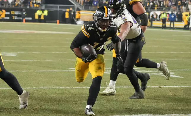 Pittsburgh Steelers running back Kenneth Gainwell (14) scores a touchdown during the second half an NFL football game against the Baltimore Ravens, Sunday, Jan. 4, 2026, in Pittsburgh. (AP Photo/Gene J. Puskar)
