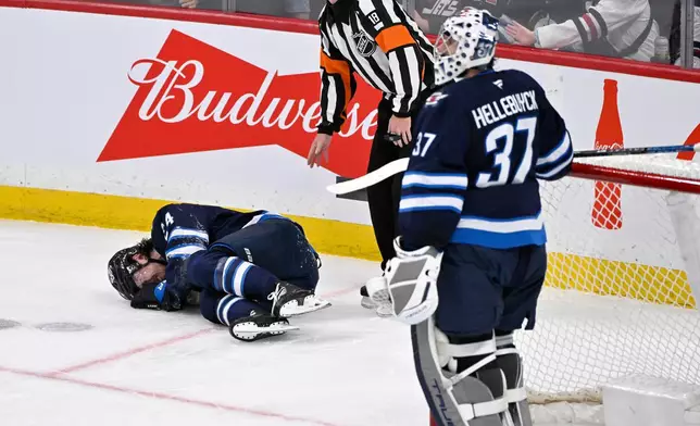 Winnipeg Jets' Haydn Fleury lies on the ice after being injured against the Vegas Golden Knights during the first period of their NHL hockey game in Winnipeg, Tuesday Jan. 6, 2026. (Fred Greenslade/The Canadian Press via AP)