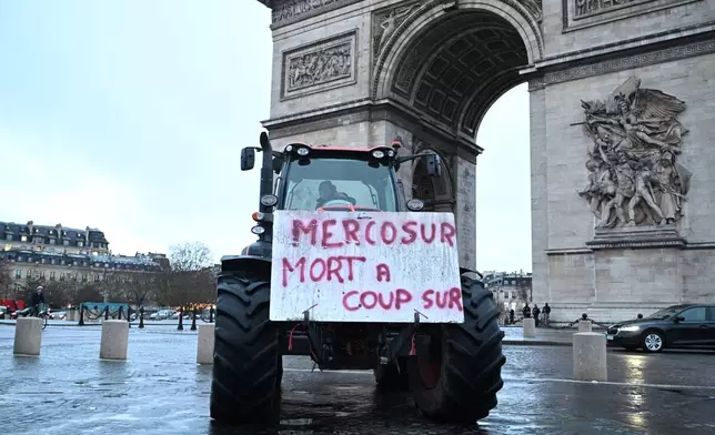 A poster on a tractor reads 'Mercosur, death for sure' as farmers protest at the Arc de Triomphe against the Mercosur trade alliance with South America countries but also against EU farming policy or mass cull of cows ordered to contain the spread of a skin disease, Thursday, Jan. 8, 2026 in Paris. (AP Photo/Emma Da Silva)