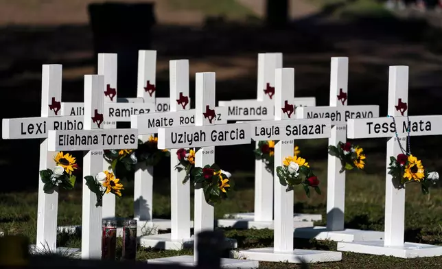 FILE - Crosses with the names of shooting victims are placed outside Robb Elementary School in Uvalde, Texas, May 26, 2022. (AP Photo/Jae C. Hong, File)