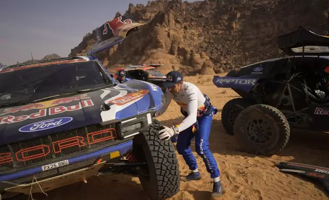 Driver Nani Roma changes a tire of his car at the end of the fourth stage of the Dakar Rally between Alula and Hail, Saudi Arabia, Wednesday, Jan. 7, 2026. (AP Photo/Thibault Camus)