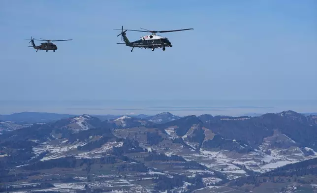 Marine One, carrying President Donald Trump, is escorted by military helicopter during his transfer to Davos after arriving at the airport in Zurich, Switzerland, Wednesday, Jan. 21, 2026. (AP Photo/Evan Vucci)