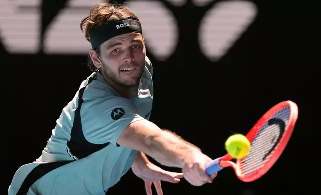 Taylor Fritz of the U.S. plays a backhand return to Lorenzo Musetti of Italy during their fourth round match at the Australian Open tennis championship in Melbourne, Australia, Monday, Jan. 26, 2026. (AP Photo/Asanka Brendon Ratnayake)