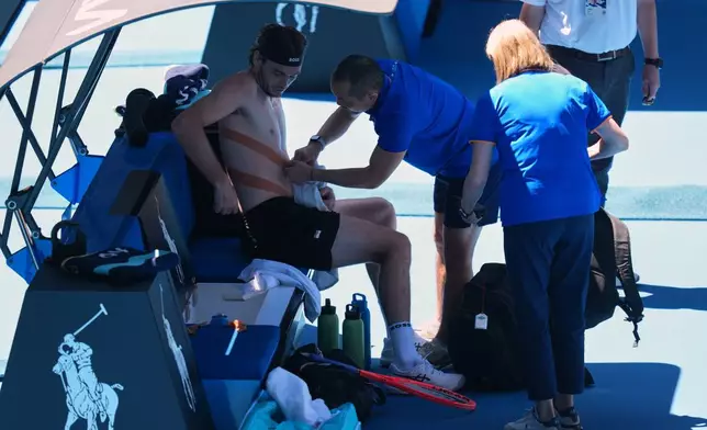 Taylor Fritz of the U.S. receives medicall attention as he plays against Lorenzo Musetti of Italy during their fourth round match at the Australian Open tennis championship in Melbourne, Australia, Monday, Jan. 26, 2026. (AP Photo/Mark Baker)