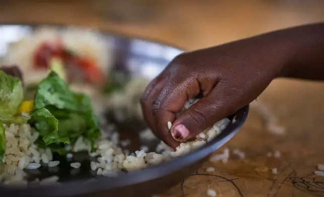 FILE - A girl eats at a school in Dollow, Somalia, Sept. 19, 2022. (AP Photo/Jerome Delay, file)