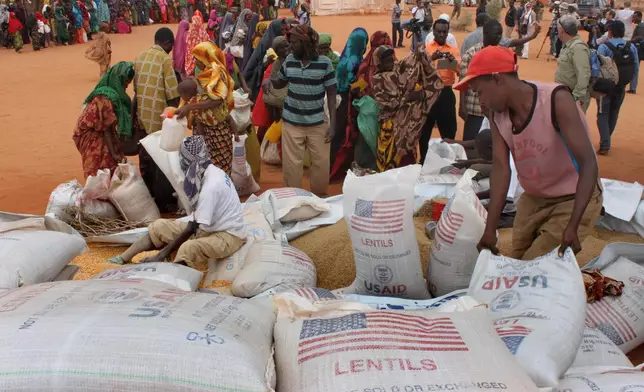 FILE - Workers distribute food aid from the World Food Program at a refugee camp in Dolo, Somalia on July 18. 2012. (AP Photo/Jason Straziuso, file)