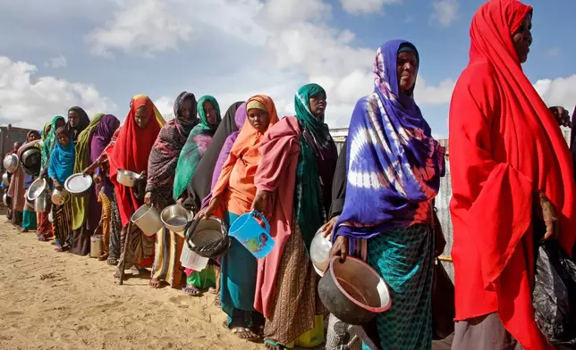 FILE - In this May 18, 2019 file photo, newly-arrived women who fled drought line up to receive food distributed by local volunteers at a camp for displaced persons in the Daynile neighborhood on the outskirts of the Somalian capital Mogadishu. (AP Photo/Farah Abdi Warsameh, file)