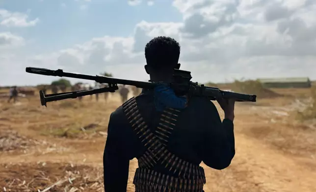 FILE - A Somalia National Army (SNA) soldier with ammunition belts strapped around him stands on the frontline in Sabiid Canole, Somalia, Nov. 11, 2025. (AP Photo/Jackson Njehia, file)