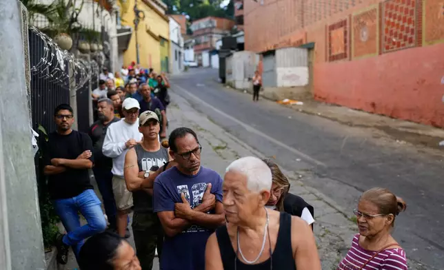 Shoppers line up at a supermarket in Caracas, Venezuela, Sunday, Jan. 4, 2026. (AP Photo/Ariana Cubillos)