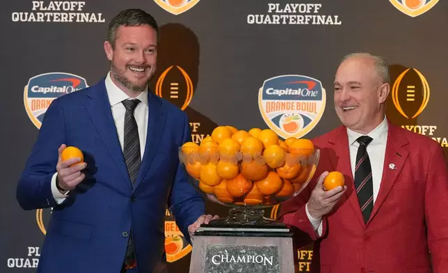Oregon head coach Dan Lanning, left, and Texas Tech head coach Joey McGuire pose with the Orange Bowl trophy at a press conference ahead of the Orange Bowl College Football Playoff quarterfinal game, Wednesday, Dec. 31, 2025, in Dania Beach, Fla. (AP Photo/Rebecca Blackwell)