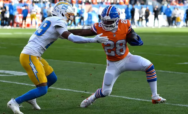 Denver Broncos running back Tyler Badie (28) runs against Los Angeles Chargers cornerback Tarheeb Still during the first half of an NFL football game, Sunday, Jan. 4, 2026, in Denver. (AP Photo/Eric Lutzens)