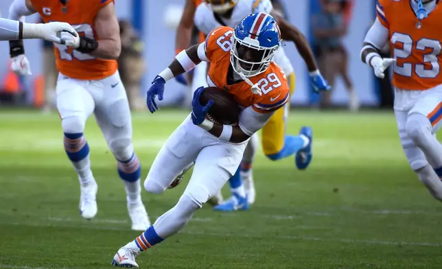 Denver Broncos cornerback Ja'quan McMillian (29) runs for a touchdown after intercepting the ball during the first half of an NFL football game against the Los Angeles Chargers, Sunday, Jan. 4, 2026, in Denver. (AP Photo/Eric Lutzens)