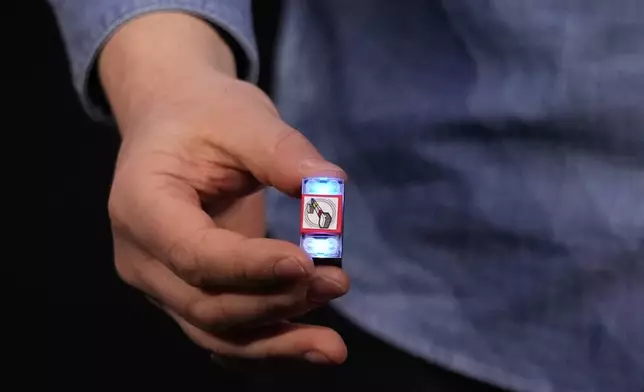A LEGO smart brick is held during a LEGO news conference ahead of the CES tech show Monday, Jan. 5, 2026, in Las Vegas. (AP Photo/Abbie Parr)
