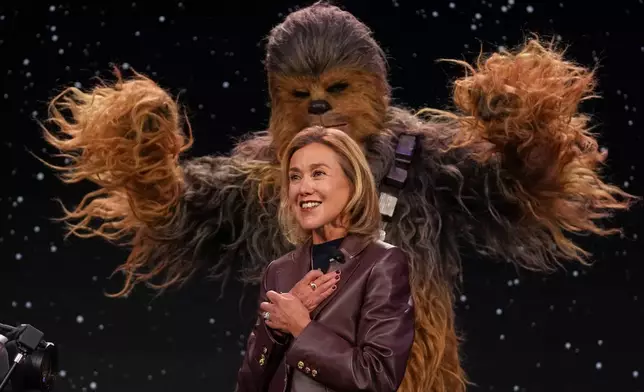 LEGO chief product and marketing officer and executive vice president Julia Goldin talks as a a Chewbacca stands behind her during an LEGO news conference ahead of the CES tech show Monday, Jan. 5, 2026, in Las Vegas. (AP Photo/Abbie Parr)