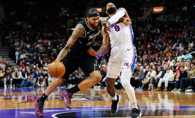 Philadelphia 76ers forward Paul George (8) fouls Toronto Raptors forward Brandon Ingram, left, during the first half of an NBA basketball game in Toronto, Monday, Jan. 12, 2026. (Frank Gunn/The Canadian Press via AP)