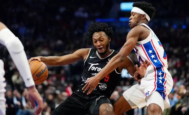 Toronto Raptors guard Immanuel Quickley (5) moves the ball under pressure from Philadelphia 76ers guard Vj Edgecombe during the first half of an NBA basketball game in Toronto, Monday, Jan. 12, 2026. (Frank Gunn/The Canadian Press via AP)