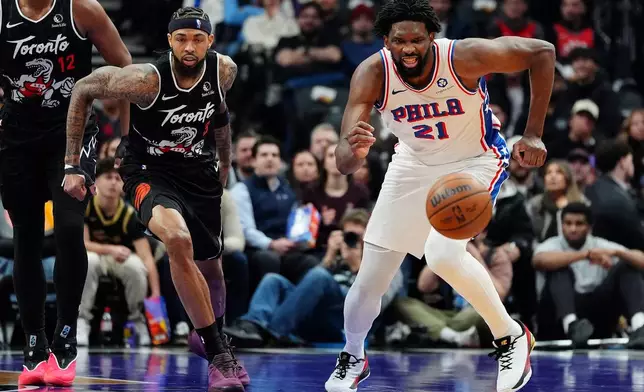 Toronto Raptors forward Brandon Ingram (3) and Philadelphia 76ers centre/forward Joel Embiid (21) vie for a loose ball during first half NBA basketball action in Toronto, Monday, Jan. 12, 2026. (Frank Gunn/The Canadian Press via AP)