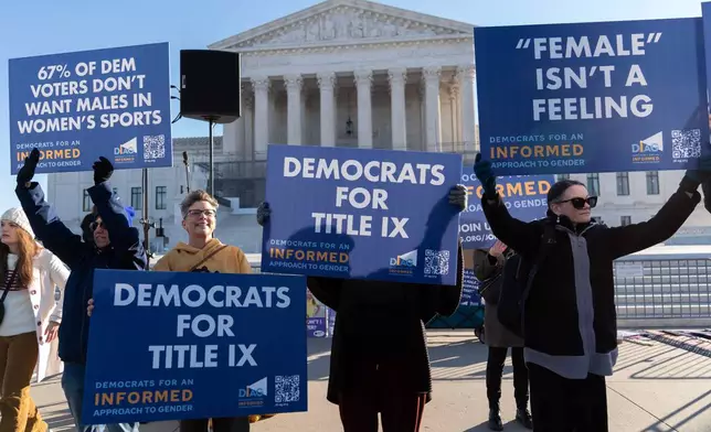 Protesters gather outside the Supreme Court as it hears arguments over state laws barring transgender girls and women from playing on school athletic teams, Tuesday, Jan. 13, 2026, in Washington. (AP Photo/Jose Luis Magana)