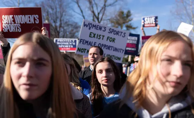 Protesters gather outside the Supreme Court as it hears arguments over state laws barring transgender girls and women from playing on school athletic teams, Tuesday, Jan. 13, 2026, in Washington. (AP Photo/Jose Luis Magana)