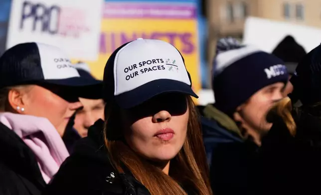 Protesters gather outside the Supreme Court as it hears arguments over state laws barring transgender girls and women from playing on school athletic teams, Tuesday, Jan. 13, 2026, in Washington. (AP Photo/Julia Demaree Nikhinson)
