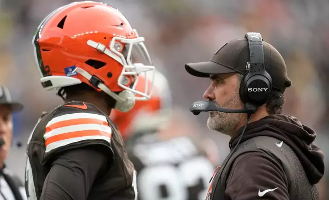 Cleveland Browns head coach Kevin Stefanski talks with quarterback Shedeur Sanders, left, during the first half of an NFL football game against the Pittsburgh Steelers, Sunday, Dec. 28, 2025, in Cleveland. (AP Photo/Sue Ogrocki)