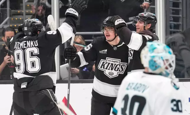 Los Angeles Kings center Alex Turcotte, second from left, cele braces his goal with left wing Andrei Kuzmenko, left, and left wing Kevin Fiala, second from right, as San Jose Sharks goaltender Yaroslav Askarov sits inn goal during the second period of an NHL hockey game Wednesday, Jan. 7, 2026, in Los Angeles. (AP Photo/Mark J. Terrill)