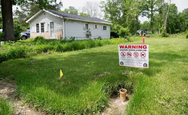A sign warns of the dangers of sewer overflows in flood-prone Cahokia Heights, Ill., May 15, 2025. (AP Photo/Michael Phillis)