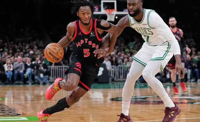 Toronto Raptors guard Immanuel Quickley (5) drives to the basket against Boston Celtics guard Jaylen Brown (7) during the first half of an NBA game, Friday, Jan. 9, 2026, in Boston. (AP Photo/Charles Krupa)