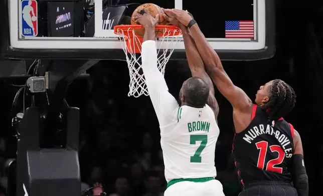 Boston Celtics guard Jaylen Brown (7) dunks against Toronto Raptors forward Collin Murray-Boyles (12) during the first half of an NBA basketball game, Friday, Jan. 9, 2026, in Boston. (AP Photo/Charles Krupa)