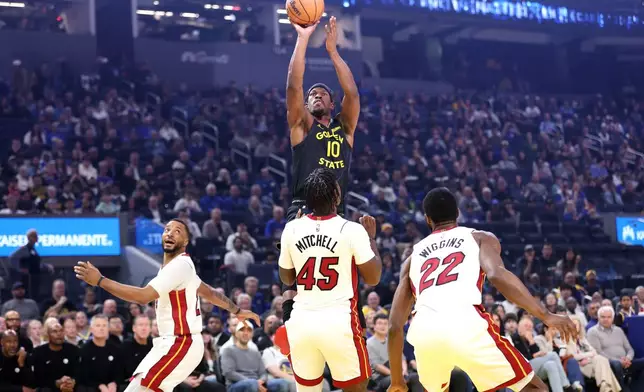 Golden State Warriors' Jimmy Butler III (10) goes up to shoot over Miami Heat's Norman Powell, left, Davion Mitchell (45) and Andrew Wiggins (22) during the first half of an NBA basketball game in San Francisco, Monday, Jan. 19, 2025. (Scott Strazzante/San Francisco Chronicle via AP)