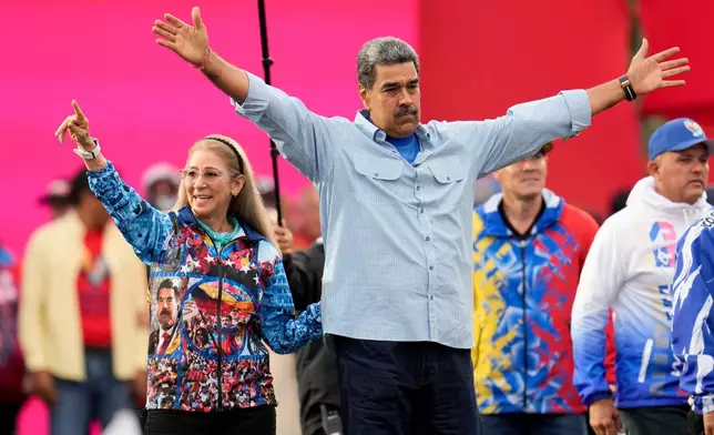 FILE - President Nicolas Maduro acknowledges supporters alongside first lady Cilia Flores during his closing election campaign rally in Caracas, Venezuela, July 25, 2024. (AP Photo/Fernando Vergara, File)