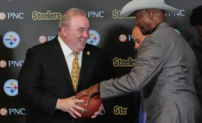Mike McCarthy, left, visits with Pittsburgh Steelers Pro Football Hall of Fame Mel Blount, right, after being introduced as the new head coach of the Pittsburgh Steelers in Pittsburgh Tuesday, Jan. 27, 2026. (AP Photo/Gene J. Puskar)