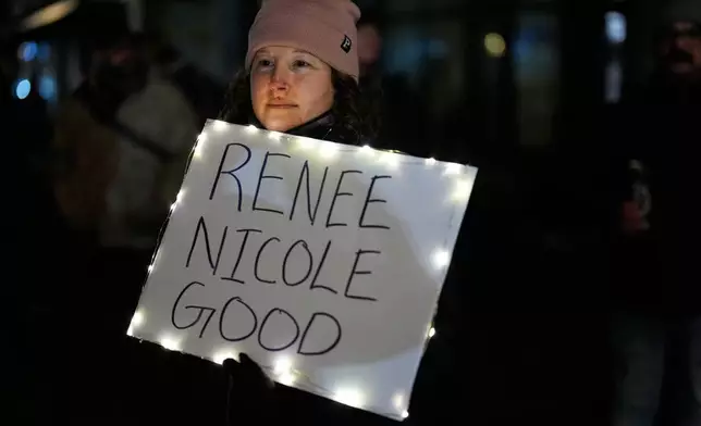 A woman holds a sign for Renee Good, who was fatally shot by an ICE officer in Minneapolis earlier in the week, as people gather outside the U.S. Immigration and Customs Enforcement facility Friday, Jan. 9, 2026, in Portland, Ore. (AP Photo/Jenny Kane)